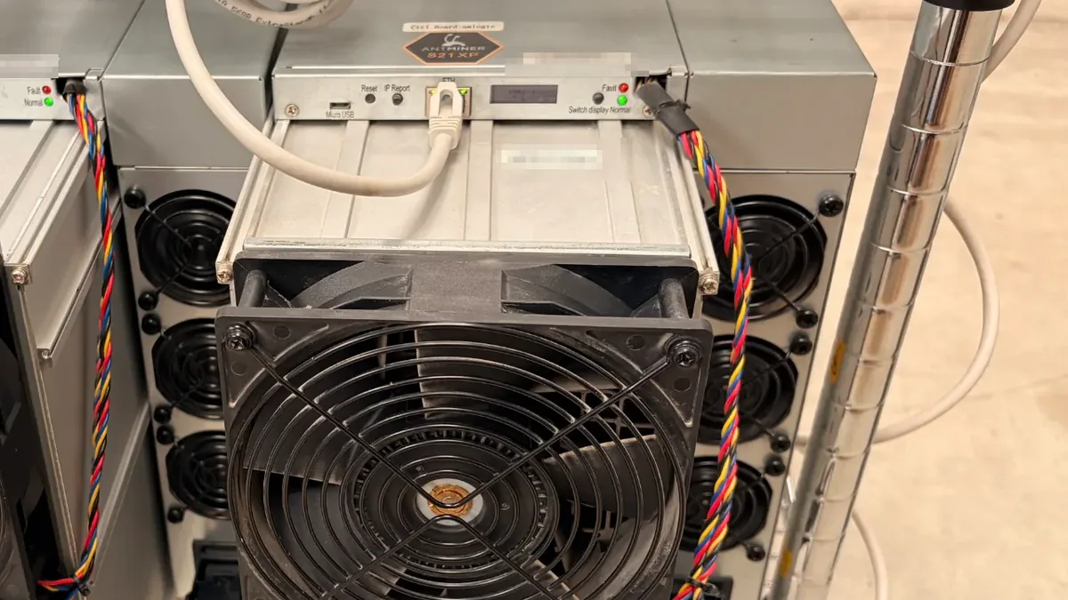 Antminer S21 XP en una estantería: cable de par trenzado en el puerto ETH, botones Reset e IP Report, indicadores Fault y Normal