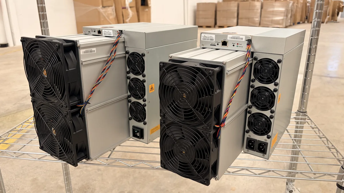 Dos ASIC industriales en una estantería de almacén: a la izquierda un Antminer L11, a la derecha un Antminer Z15 Pro, con los ventiladores en los extremos, la placa de control con puerto Ethernet y los conectores de alimentación